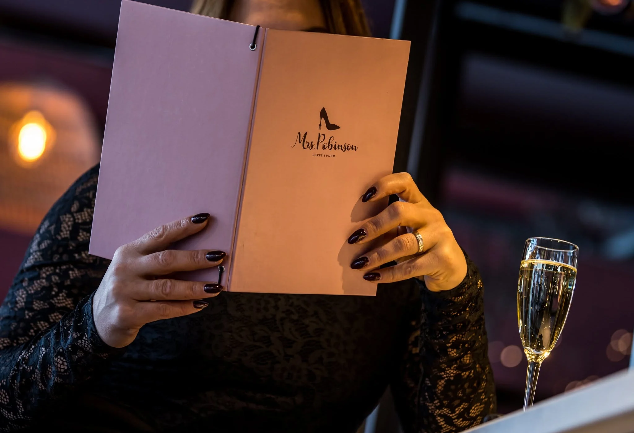 Gast leest de menukaart met een glas champagne
