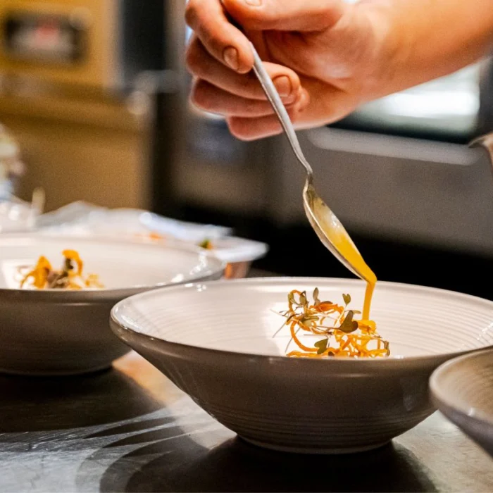 Kok schenkt saus op in de keuken